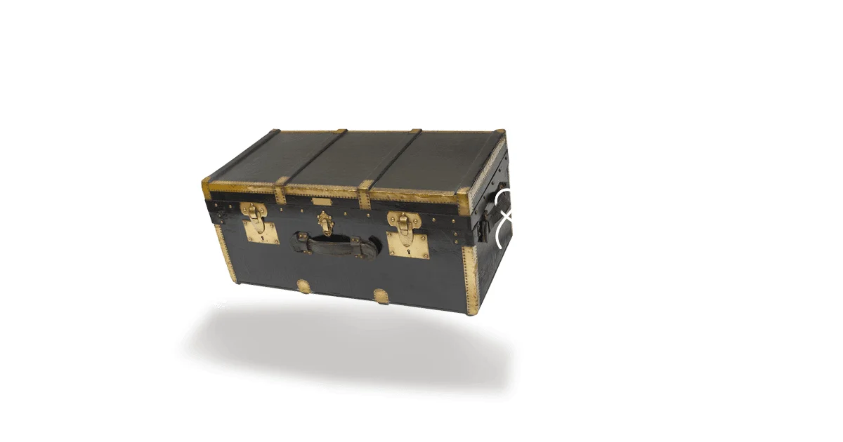 A black steamer trunk with brass corners and latches floating above its shadow on a white background